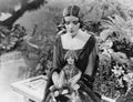 Woman sitting in garden with doll Royalty Free Stock Photo