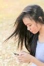 Woman sitting in garden using a mobile telephone