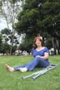 Woman sitting on the grass with a bandaged foot and crutches at her side Royalty Free Stock Photo