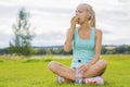 Woman sitting at the grass and eating apple after workout Royalty Free Stock Photo