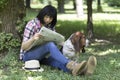 Woman sitting in the grass in the park reading the newspaper and Royalty Free Stock Photo