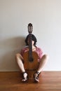 A woman sitting with a guitar