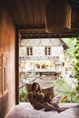 Woman sitting in hammock with colorful pillows and drinking fresh young coconut Royalty Free Stock Photo