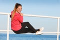 Woman sitting on handrail by the sea Royalty Free Stock Photo