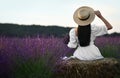 Woman sitting on hay bale in lavender field, back Royalty Free Stock Photo