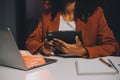 Woman sitting at her desk in home office working late at night using laptop computer; female web designer working overtime Royalty Free Stock Photo