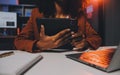 Woman sitting at her desk in home office working late at night using laptop computer; female web designer working overtime Royalty Free Stock Photo