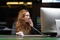 Woman sitting at her desk working and answering a phone call Royalty Free Stock Photo