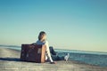 woman sitting on her suitcase waiting for the sunset in a spectacular view Royalty Free Stock Photo