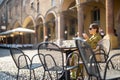 Woman sitting with her white dog at outdoor cafe in the old town of Bologna city Royalty Free Stock Photo