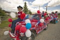 Woman sitting on the hood of a jeep decorated for the Fourth of July, in Lima Montana