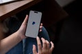 A woman sitting indoors and using a PayPal application through her Iphone14. A PayPal logo