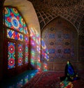 Woman sitting inside with stained glass window reflections of Nasir al-Mulk Mosque, Shiraz, Iran Royalty Free Stock Photo