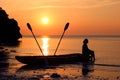 Woman sitting on a kayak on the beach. Royalty Free Stock Photo