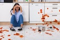 Woman Sitting On Kitchen Floor With Spilled Food Royalty Free Stock Photo