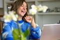 Woman sitting laughing at her laptop computer Royalty Free Stock Photo