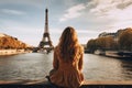 Woman Sitting Ledge, Looking Eiffel Tower, Paris, France, Young traveler woman rear view sitting on the quay of Seine River