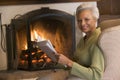 Woman sitting in living room by fireplace Royalty Free Stock Photo