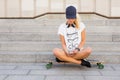 Woman sitting on longboard and texting