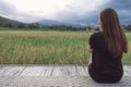 A woman sitting and looking at a beautiful rice field onward with feeling relaxed Royalty Free Stock Photo