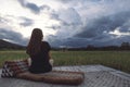 A woman sitting and looking at a beautiful rice field onward with feeling relaxed Royalty Free Stock Photo