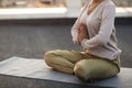 Woman sitting in lotus pose on mat and practicing yoga, female meditating outdoors Royalty Free Stock Photo