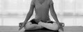 Woman sitting on lotus position on floor legs crossed with eyes closed for meditating. Yoga at home,monochrome 