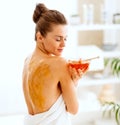 Woman sitting on massage table with honey plate Royalty Free Stock Photo