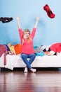 Woman sitting on messy couch throwing clothes Royalty Free Stock Photo