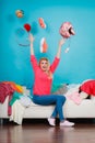 Woman sitting on messy couch throwing clothes Royalty Free Stock Photo