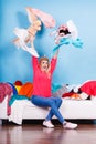 Woman sitting on messy couch throwing clothes Royalty Free Stock Photo