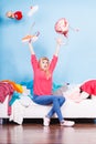 Woman sitting on messy couch throwing clothes Royalty Free Stock Photo