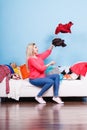 Woman sitting on messy couch throwing clothes Royalty Free Stock Photo