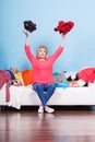 Woman sitting on messy couch throwing clothes Royalty Free Stock Photo
