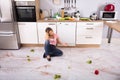 Woman Sitting On Messy Kitchen Floor Royalty Free Stock Photo