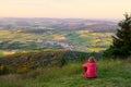 A woman sitting on mount Hohenbogen, looking to Neukirchen Heiligblut, a small town in the Bavarian Forest Royalty Free Stock Photo