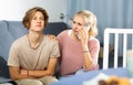 Woman sitting near her sad son and calling to doctor Royalty Free Stock Photo