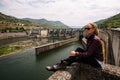 Woman sitting near an old hydroelectric plant. Stroll. Royalty Free Stock Photo