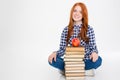 Woman sitting near stack of books with apple on top Royalty Free Stock Photo