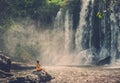 Woman sitting near waterfall enjoying the sun, Phnom Koulen at Siem Reap, Cambodia Royalty Free Stock Photo