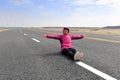 Woman sitting on new road in winter