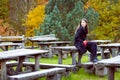 Woman sitting on old park cafe wooden table in Royalty Free Stock Photo