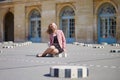 Woman sitting on one of the Colonnes de Buren in Paris Royalty Free Stock Photo