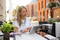 Woman sitting in outdoor cafe and using tablet Royalty Free Stock Photo