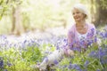 Woman sitting outdoors with flowers smiling Royalty Free Stock Photo