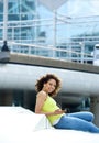 Woman sitting outdoors with music device