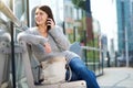 Woman sitting outside in the city listening to cell phone Royalty Free Stock Photo