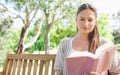 Woman sitting on a park bench while reading a book Royalty Free Stock Photo