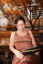 Woman sitting on a park bench and reading e-book Royalty Free Stock Photo