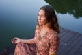 Woman sitting at the pier in lotus position Royalty Free Stock Photo